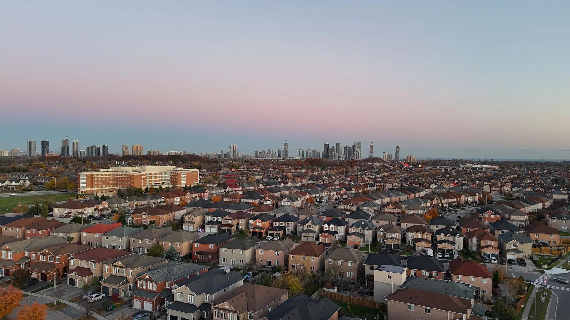 Aerial view of Mississauga, Ontario homes and streets with the city centre skyline at dusk