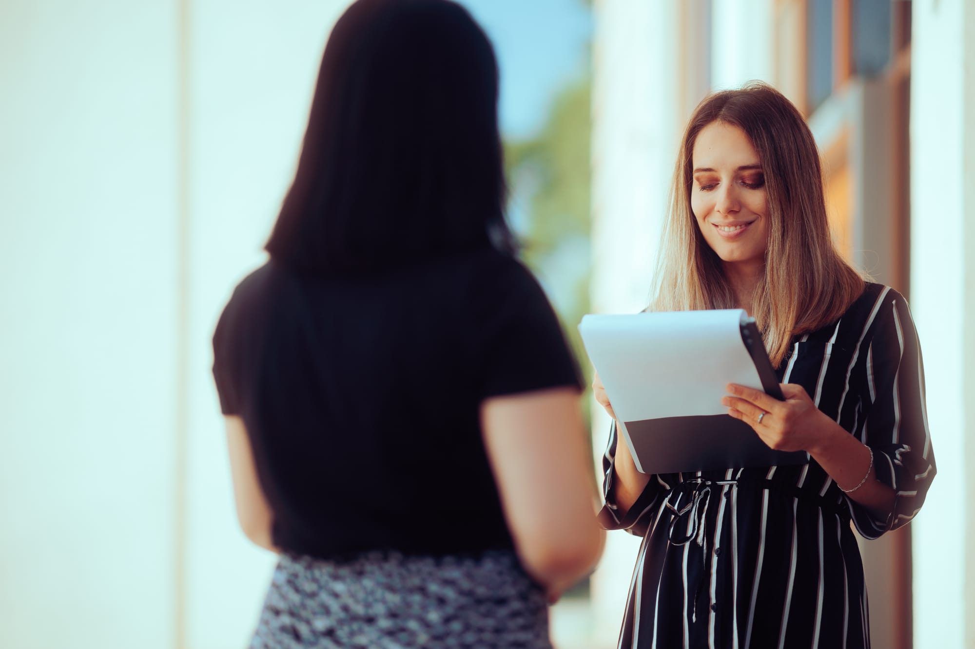 Real Estate agent speaking with a homeowner while reviewing an interviez checklist