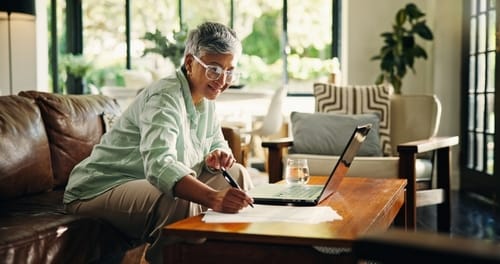 A home buyer reviewing real estate agent agreements and costs on a laptop